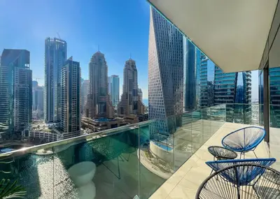 a balcony with two chairs and a view of a city at Livbnb - 2BR Apartment with Breathtaking Marina View in Dubai