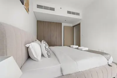 a bedroom with a large white bed with white pillows at Luxury 1BR apartment at Creek Edge Tower 2 in Dubai