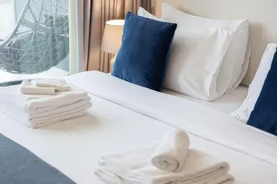 a bed with towels and pillows on it at Lux Apartment with huge private Lounge I Burj & Canal View in Dubai