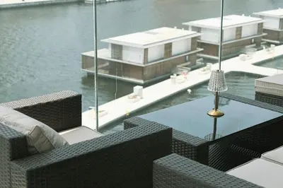 a balcony with a table and chairs next to the water at Lux Apartment with huge private Lounge I Burj & Canal View in Dubai