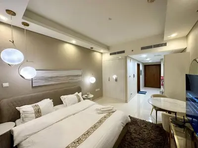 a large bedroom with a large bed and a table at Modern Furnished Studio with Canal View , High Floor in Dubai