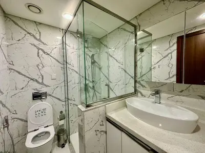 a bathroom with a sink and a glass shower at Modern Furnished Studio with Canal View , High Floor in Dubai