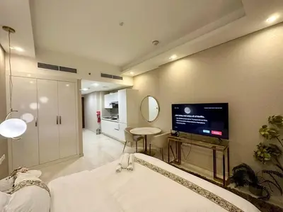 a living room with a flat screen tv on the wall at Modern Furnished Studio with Canal View , High Floor in Dubai