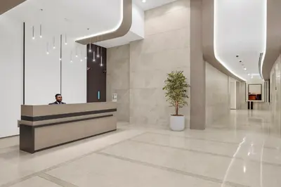 a man sitting at a reception desk in a lobby at Burj Khalifa View 2BR Steps from Dubai Mall & Metro in Dubai