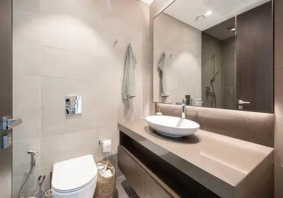 a bathroom with a sink and a toilet and a mirror at Jumeirah Living Marina Gate - Golf & Skyline Views with Pool & Gym in Dubai