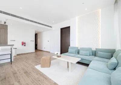 a living room with a blue couch and a table at Jumeirah Living Marina Gate - Golf & Skyline Views with Pool & Gym in Dubai