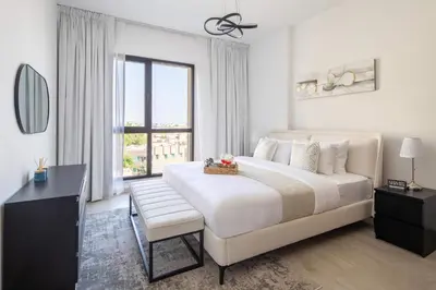 a white bedroom with a large bed and a window at Frank Porter - Lamtara 3 in Dubai