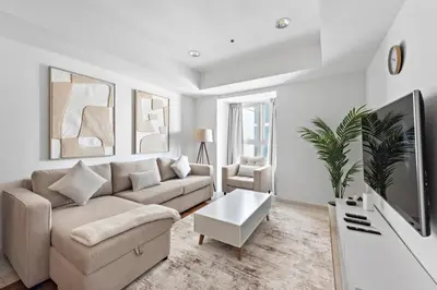 a living room with a couch and a tv at Cozy 1-Bedroom Apartment In Princess Tower in Dubai
