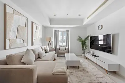 a living room with a couch and a tv at Cozy 1-Bedroom Apartment In Princess Tower in Dubai