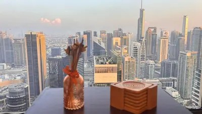 two vases sitting on a table with a view of a city at JBR Marina View - 2BR Apartment in Dubai