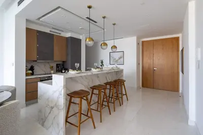 a kitchen with a marble counter and bar stools at Frank Porter - The One JBR in Dubai