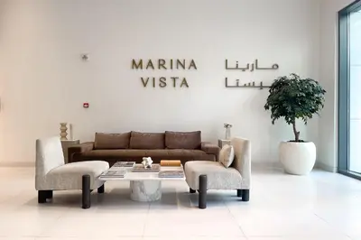 a living room with a couch and two chairs and a table at Marina Vista Private Beach 2BR in Dubai