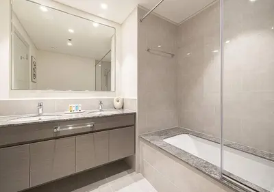 a bathroom with a tub and a sink and a mirror at Downtown Sky High Luxury Apartment I City And Sea Views I Opp Dubai Mall Burj Khalifa in Dubai