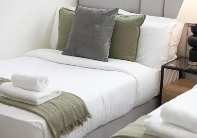 a white couch with green pillows and a table at Downtown Sky High Luxury Apartment I City And Sea Views I Opp Dubai Mall Burj Khalifa in Dubai