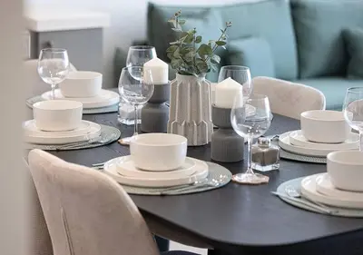a black table with white plates and wine glasses at Downtown Sky High Luxury Apartment I City And Sea Views I Opp Dubai Mall Burj Khalifa in Dubai