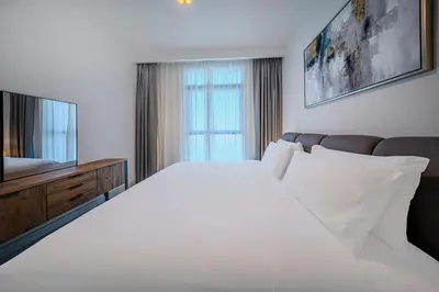 a bedroom with a white bed and a television at Stunning 1 bedroom sea view apartment in Dubai