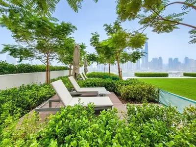 a patio with two white chairs and an umbrella at Stunning 1 bedroom sea view apartment in Dubai