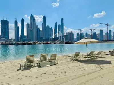 a beach with chairs and an umbrella and a city at Stunning 1 bedroom sea view apartment in Dubai