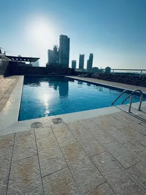 a swimming pool with a city skyline in the background at Apartment in Al Barsha1 Near by Metro in Dubai