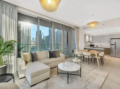 a living room with a couch and a table and a kitchen at Dream Location - Luxury and Comfort in Dubai in Dubai