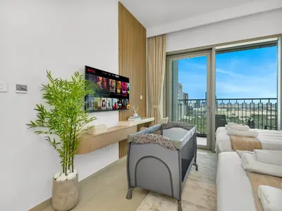 a living room with a couch and a tv at Blissful Stays - Luxury Two Bedroom Apartment at Downtown Views II- 5 min walk to Dubai Mall, Burj Khalifa with Infinity Pool in Dubai