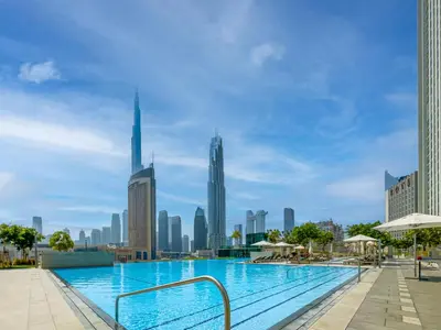 a swimming pool with a city skyline in the background at Blissful Stays - Luxury Two Bedroom Apartment at Downtown Views II- 5 min walk to Dubai Mall, Burj Khalifa with Infinity Pool in Dubai