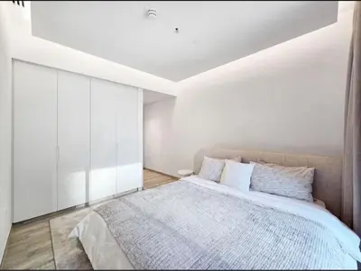 a bedroom with a large bed with white walls at FIRST CLASS 1BR Charming City in Dubai