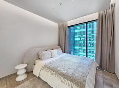 a bedroom with a bed and a large window at FIRST CLASS 1BR Charming City in Dubai