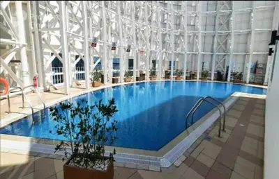 a large swimming pool in a large building at Charming & Comfortable 1BR Jumeirah Bay X1 JLT in Dubai