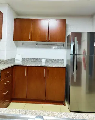 a kitchen with wooden cabinets and a stainless steel refrigerator at Charming & Comfortable 1BR Jumeirah Bay X1 JLT in Dubai
