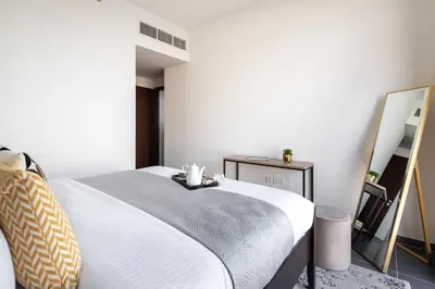 a bedroom with a white bed and a mirror at Frank Porter - Creek Edge Tower 1 in Dubai