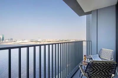 a balcony with a chair and a view of the water at Frank Porter - Creek Edge Tower 1 in Dubai