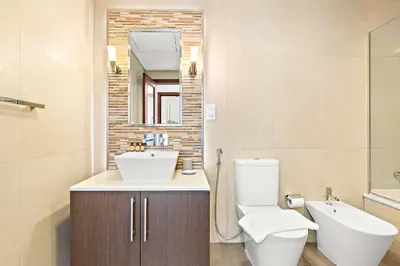 a bathroom with a toilet and a sink and a mirror at Silkhaus Burj Khalifa & Zaabeel View in Burj Daman in Dubai
