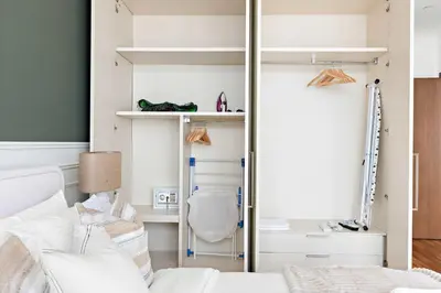 a bedroom with a bed and a closet with shelves at Silkhaus Burj Khalifa & Zaabeel View in Burj Daman in Dubai