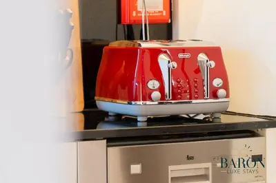 a red toaster sitting on top of a microwave at The Charming in Dubai