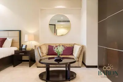 a living room with a couch and a table with a mirror at The Charming in Dubai
