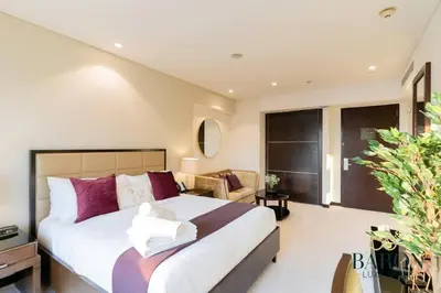 a bedroom with a large bed with purple pillows at The Charming in Dubai