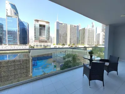 a balcony with a table and chairs and a view of a city at Cozy 2BR Apartment DAMAC VERA Business Bay in Dubai