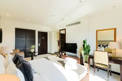 a living room with a white bed and a desk at The Magnificent in Dubai