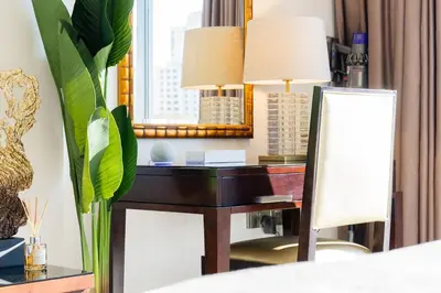 an office with a desk with a mirror and a lamp at The Magnificent in Dubai