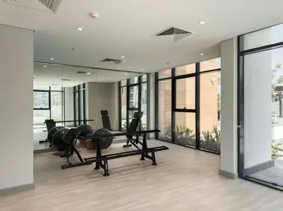 a gym with treadmills elliptical machines and a mirror at Newly Furnished Studio Azizi Riviera 37 Al Meydan in Dubai