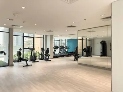 a gym with treadmills and ellipticals and mirrors at Newly Furnished Studio Azizi Riviera 37 Al Meydan in Dubai
