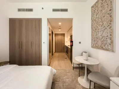 a bedroom with a bed and a small table at Newly Furnished Studio Azizi Riviera 37 Al Meydan in Dubai