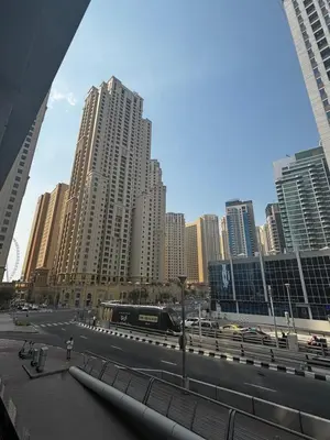 a train traveling through a city with tall buildings at Sparkle Skyline Studio - Contemporary Living in Dubai
