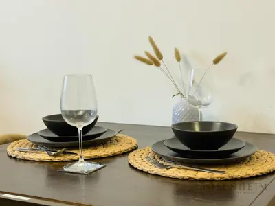 a table with two glasses and two plates and bowls at Sparkle Skyline Studio - Contemporary Living in Dubai