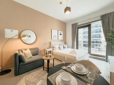 a bedroom with a bed and a couch and a table at Luxury Canal View Studio at Sparkle Tower in Dubai