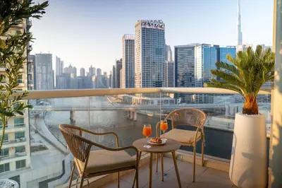 a balcony with a table and chairs and a view of a city at Skyline Dream - 1 BHK - Burj and Canal views in Dubai