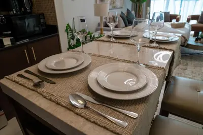 a table with plates and wine glasses on it at Skyline Dream - 1 BHK - Burj and Canal views in Dubai