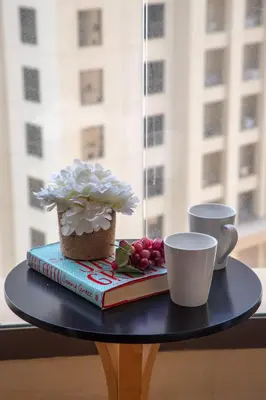 a table with a book and a cup of coffee at Frank Porter - Murjan 1 in Dubai