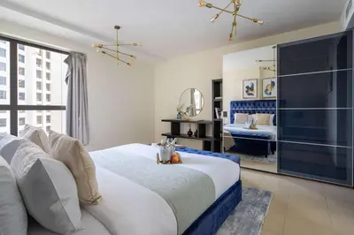 a bedroom with a large bed and a bathroom at Frank Porter - Murjan 1 in Dubai